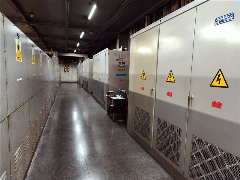 A technical corridor housing a subsynchronous cascade unit alongside multiple electrical cabinets and auxiliary components used for controlling high‑power slip ring motor systems in industrial environments.